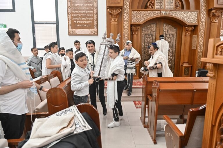 חתן בר מצווה נושא את ספר התורה לבימה